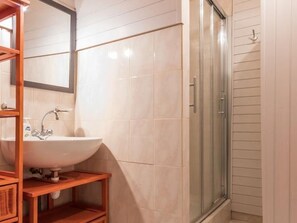 A bathroom with a white sink, wooden vanity, and a glass shower enclosure. - Charming Cottage in the Vosges Saônoises (Saint-Bresson)