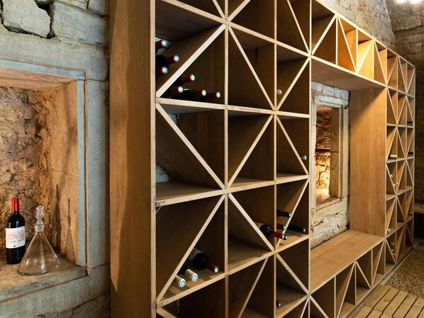 Una bodega con estanterías de madera y pared de piedra.