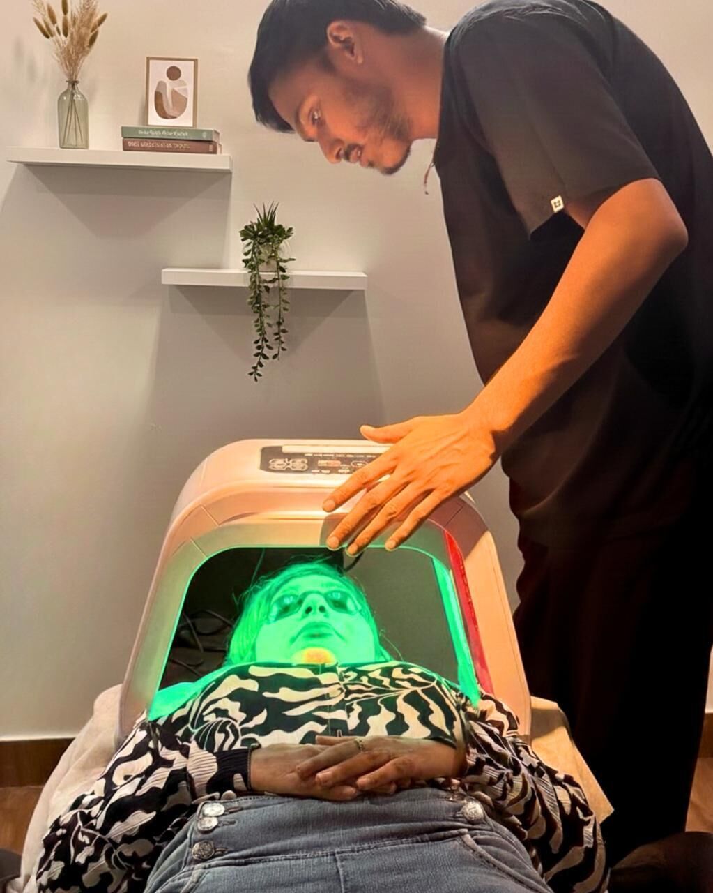 A person lying on a treatment bed with a therapist standing beside them.