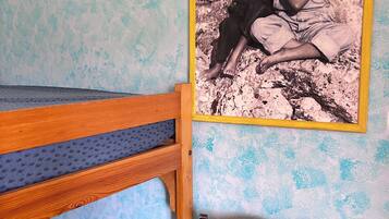 A bunk bed with a wooden frame and a mattress with a textured cover.