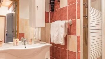 Une salle de bain avec un grand lavabo, un miroir et un porte-serviettes.