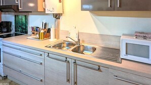 Una cucina moderna con elettrodomestici in acciaio inossidabile, mobili in legno e un forno a microonde integrato.