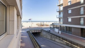 Blick auf ein Gebäude mit einem Balkon über einem Strand.