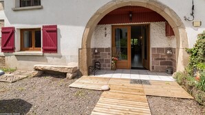 Un edificio con fachada de piedra, puerta de madera y un pequeño porche.