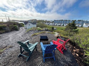 A gravel area with outdoor seating and a view of a residential area with houses.