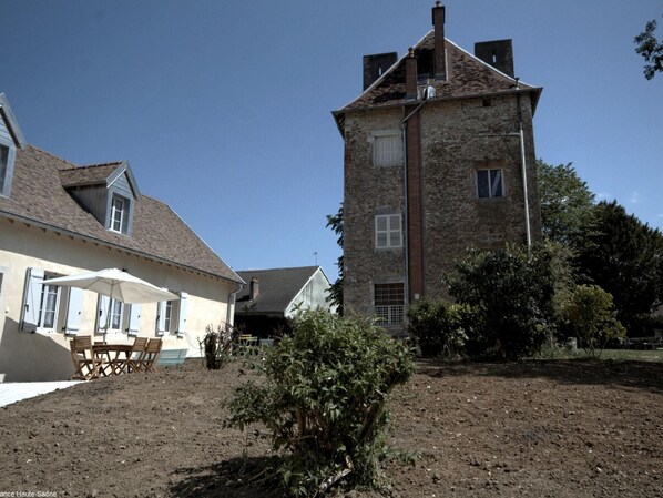 A rustic stone building with a pitched roof and a small window.