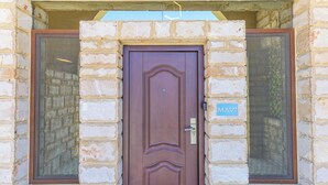 A brown door with a keyhole and a sign above it. - Mavi 1BR Apartment With Jacuzzi In Batroun (Batroun)