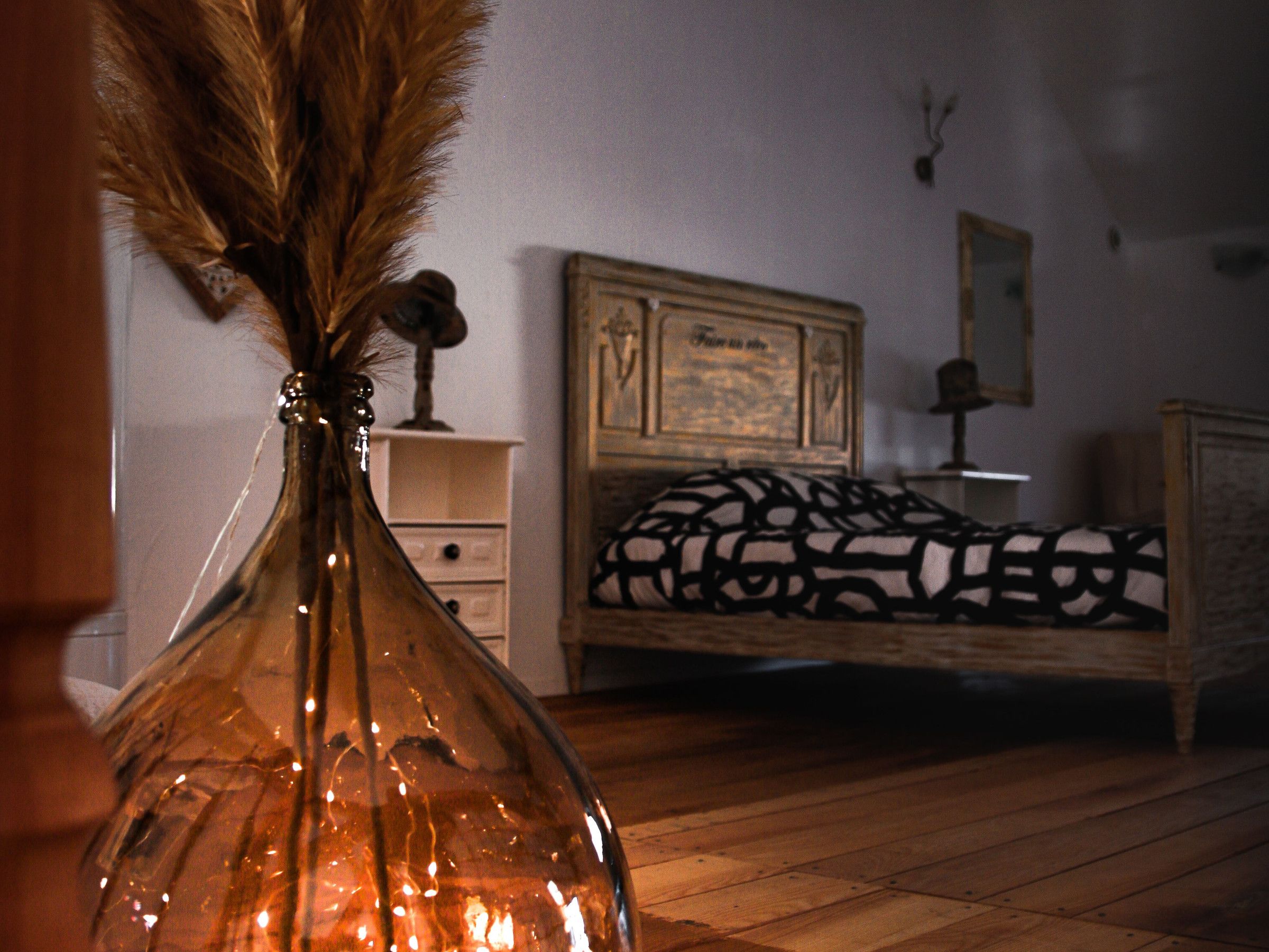 Une chambre à coucher avec un lit en bois, une table de chevet et une commode.