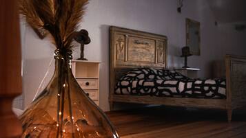 Een slaapkamer met een houten bed, een nachtkastje en een bedtafel.
