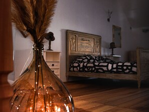 A bedroom with a wooden bed, a bedside table, and a nightstand.