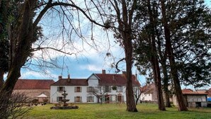 A large white building with a fountain in the center, surrounded by trees and a grassy lawn. - Cozy Cottage by the Saône (Mantoche)