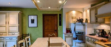 A kitchen with a marble countertop, wooden cabinets, and a built-in oven.