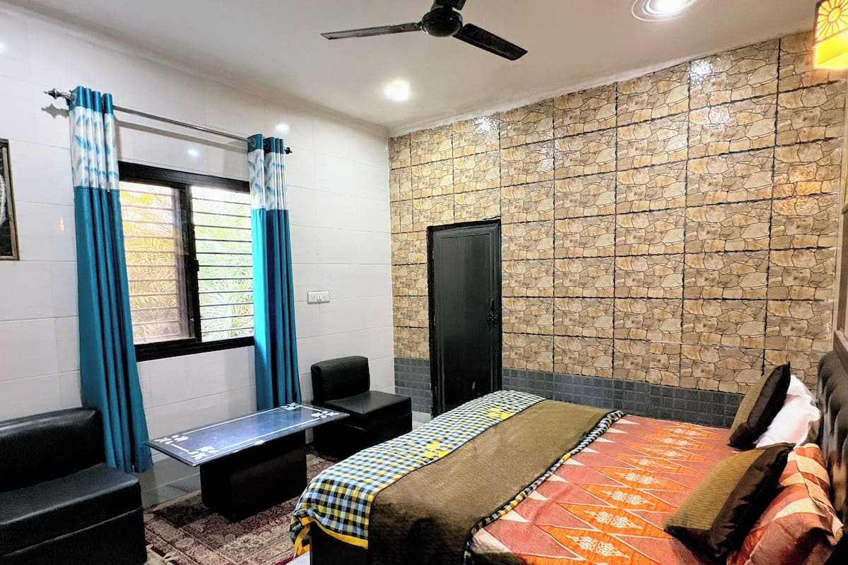 A bedroom with a bed, a desk, and a chair.
