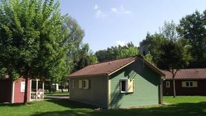Une petite maison de plain-pied, dotée d’un toit en pente, d’un petit garage attenant et d’une pelouse bien entretenue.