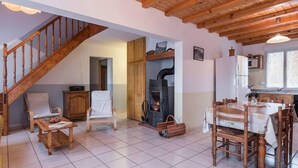 Un salón acogedor con una escalera de madera, una chimenea, un comedor y una cocina.
