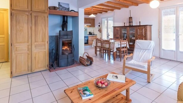 Un salón amplio con chimenea, muebles de madera y un comedor.
