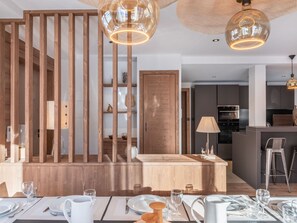 A modern dining area with wooden paneling, a central island, and pendant lighting. - Duplex in Méribel for 12 people, 145 m², WIFI (Méribel)