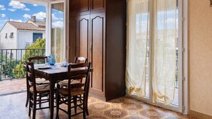 A dining area with a table and chairs, a cabinet, and a sliding glass door to a balcony. - Studio rental, steps from the beach with parking - La Londe-les-Maures (La Londe-les-Maures)