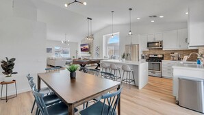 A modern kitchen with white cabinets, a central island, and stainless steel appliances.