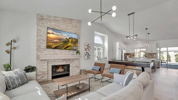 A modern living room with a fireplace, a large TV, and a pool table.