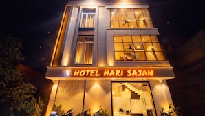 Egy többemeletes szálloda, melynek földszintjén egy feltűnő, világító felirat hirdeti: „HOTEL HARI SAJAN”.