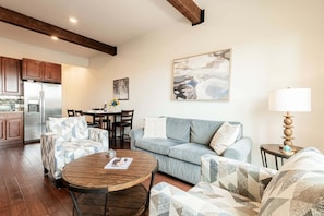 Un salon comprenant un canapé, des fauteuils, une table basse et un coin repas avec des chaises et une table.