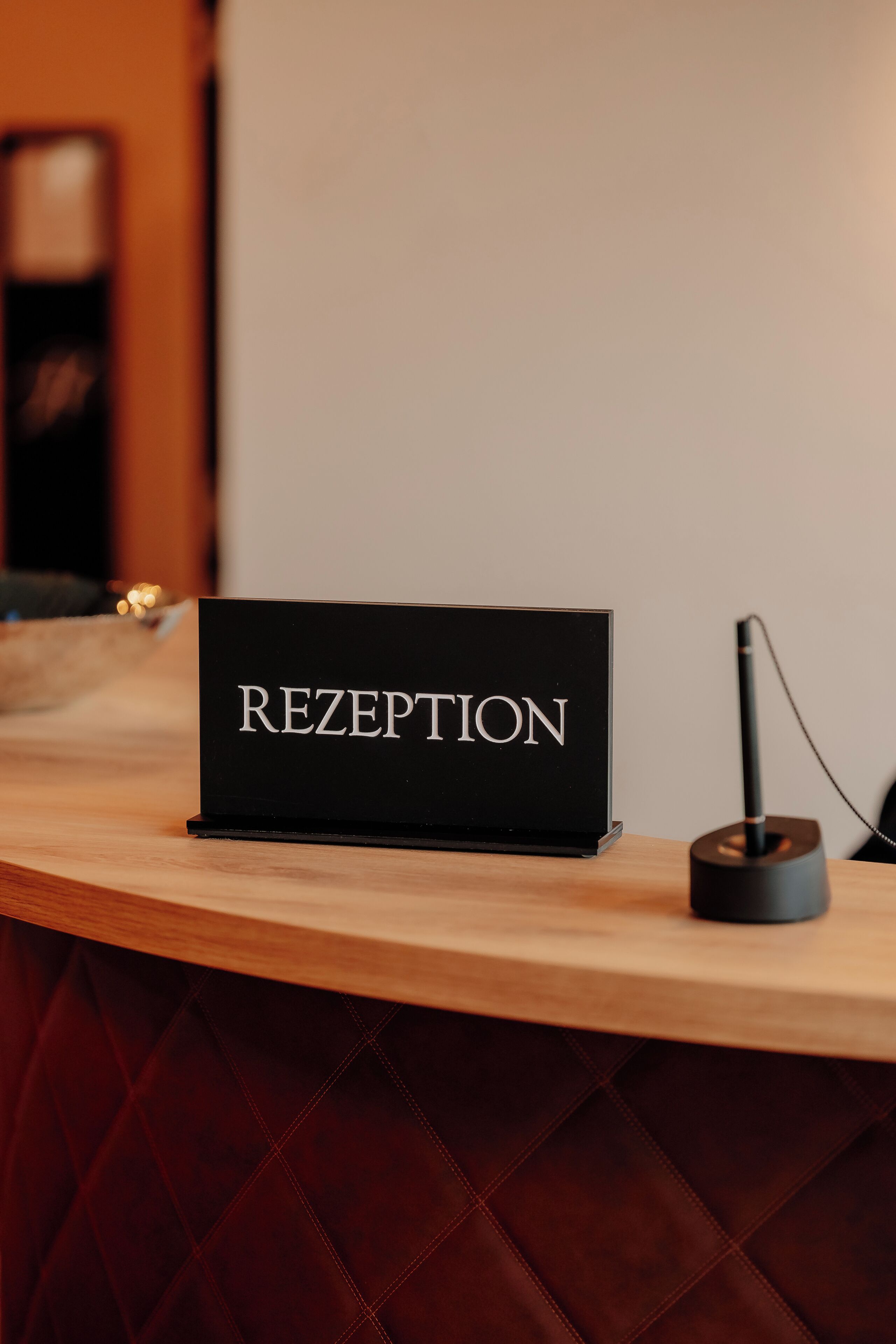 Un mostrador de recepción con un cartel que dice 'RECEPTION' y un micrófono en la encimera.