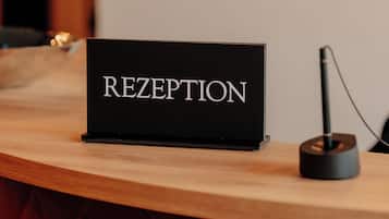 Un mostrador de recepción con un cartel que dice 'RECEPTION' y un micrófono en la encimera.