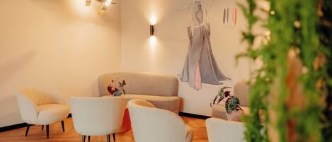A modern interior with a sofa, two armchairs, and a wall-mounted illustration.
