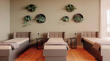 A modern bedroom with three beds, a central bench, and wall-mounted planters.