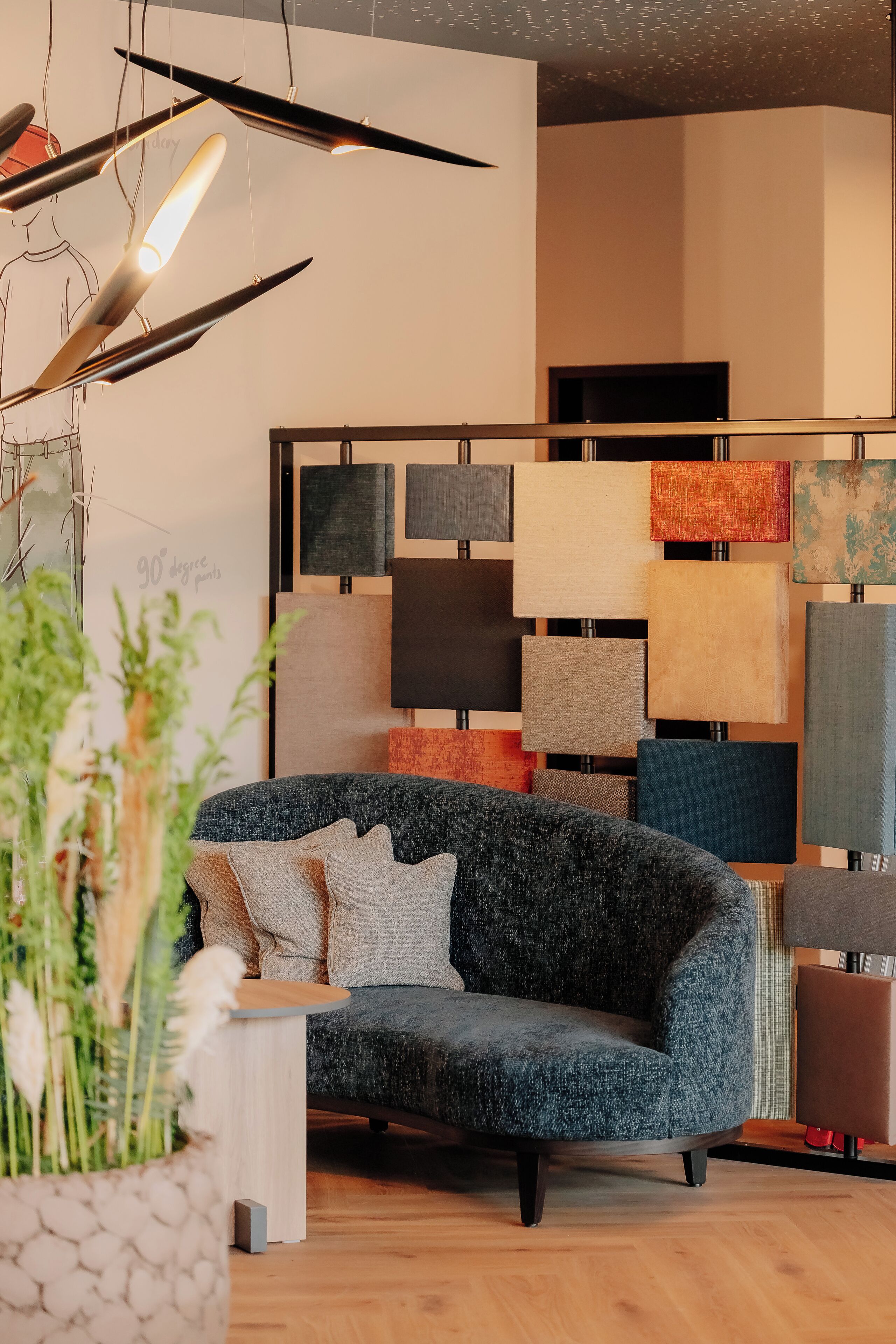 Una sala de estar moderna con un sofá gris, una mesa de centro de madera y varios apliques de pared.