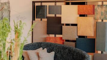 Una sala de estar moderna con un sofá gris, una mesa de centro de madera y varios apliques de pared.
