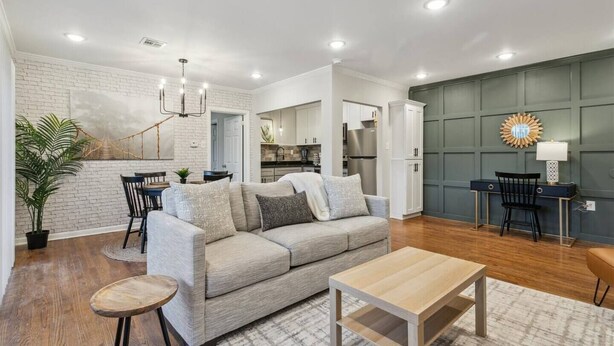 A modern living room with a sofa, coffee table, and dining area.