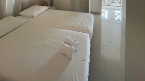 A bedroom with a bed, a ceiling fan, a closet, and a balcony view. - Villa 1A Relax & Dive Resort Bonaire Village (Kralendijk)