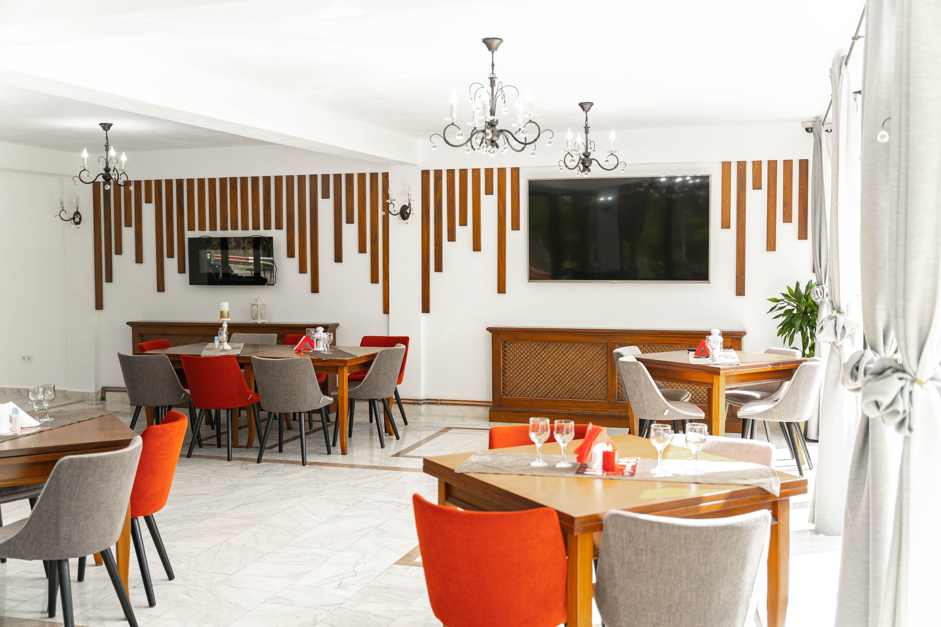 Un comedor moderno con una mesa de madera, sillas y un televisor montado en la pared.
