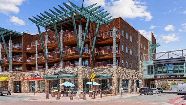 A multi-story building with a stone facade, balconies, and a coffee shop named "CUPPA COFFEE" at the ground level.