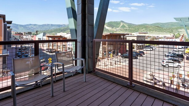 A balcony with a view of a parking lot and mountains. - Newpark 314 | Private Hot Tub | Kitchenette | Mtn & Preserve View | Fireplace | Pool & Hot Tub (Park City)