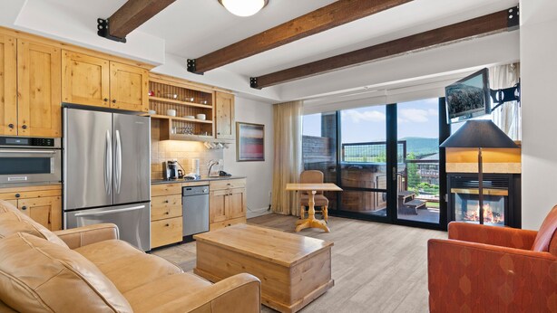 Eine moderne Küche mit Edelstahlgeräten, Holzschränken und einem großen Fenster mit Blick auf eine schöne Aussicht.