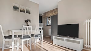 A modern living room with a dining area, a flat-screen TV, and a window with a view. - Black Forest moment at Monbachtal (Bad Liebenzell)