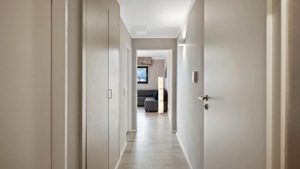 A hallway with a wooden floor leading to a living area with a sofa and a lamp. - Black Forest moment at Monbachtal (Bad Liebenzell)