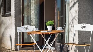 A small outdoor table with a potted plant, two white chairs, and a pair of white cups. - Black Forest moment at Monbachtal (Bad Liebenzell)