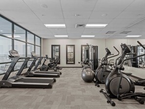 Ein Fitnessraum mit Laufbändern, Crosstrainern und Gymbällen.