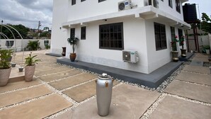 Ein mehrstöckiges Gebäude mit weißer Fassade, zahlreichen Fenstern und Klimaanlagen.