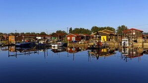 A waterfront area with boats docked, wooden buildings, and a clear sky. - 300m from beach, Andernos centre – sleeps 4 (Andernos-les-Bains)