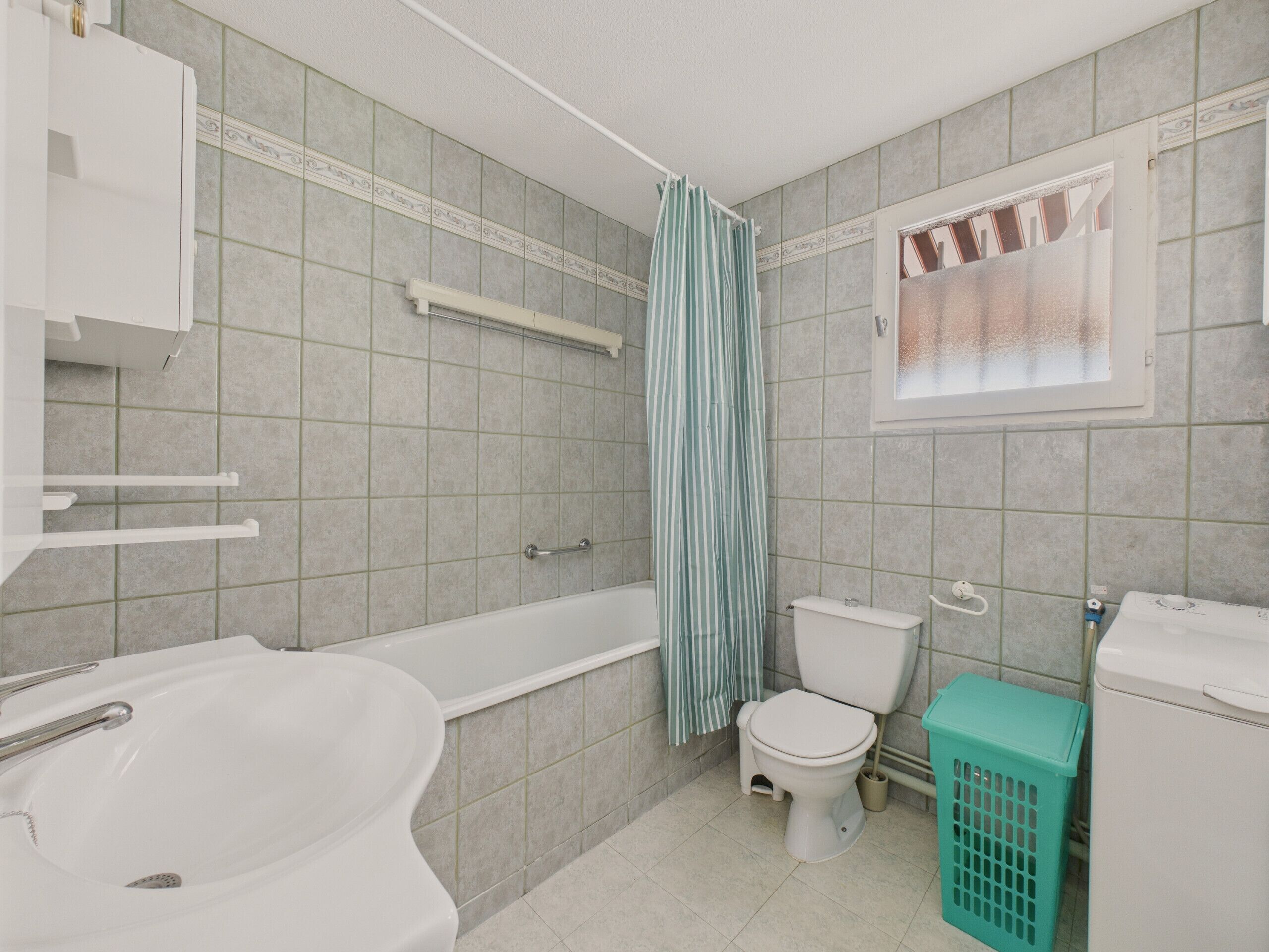 A bathroom with a bathtub, toilet, and sink.