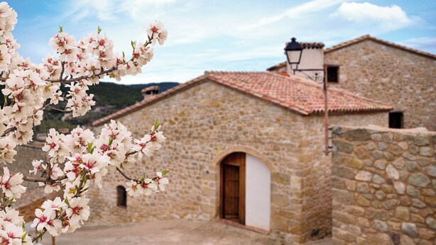 A stone building with a tiled roof and a small arched entrance. - Charming barn in the Matarraña, patio with barbecue and AC - Casa de las Letras (Liedo)
