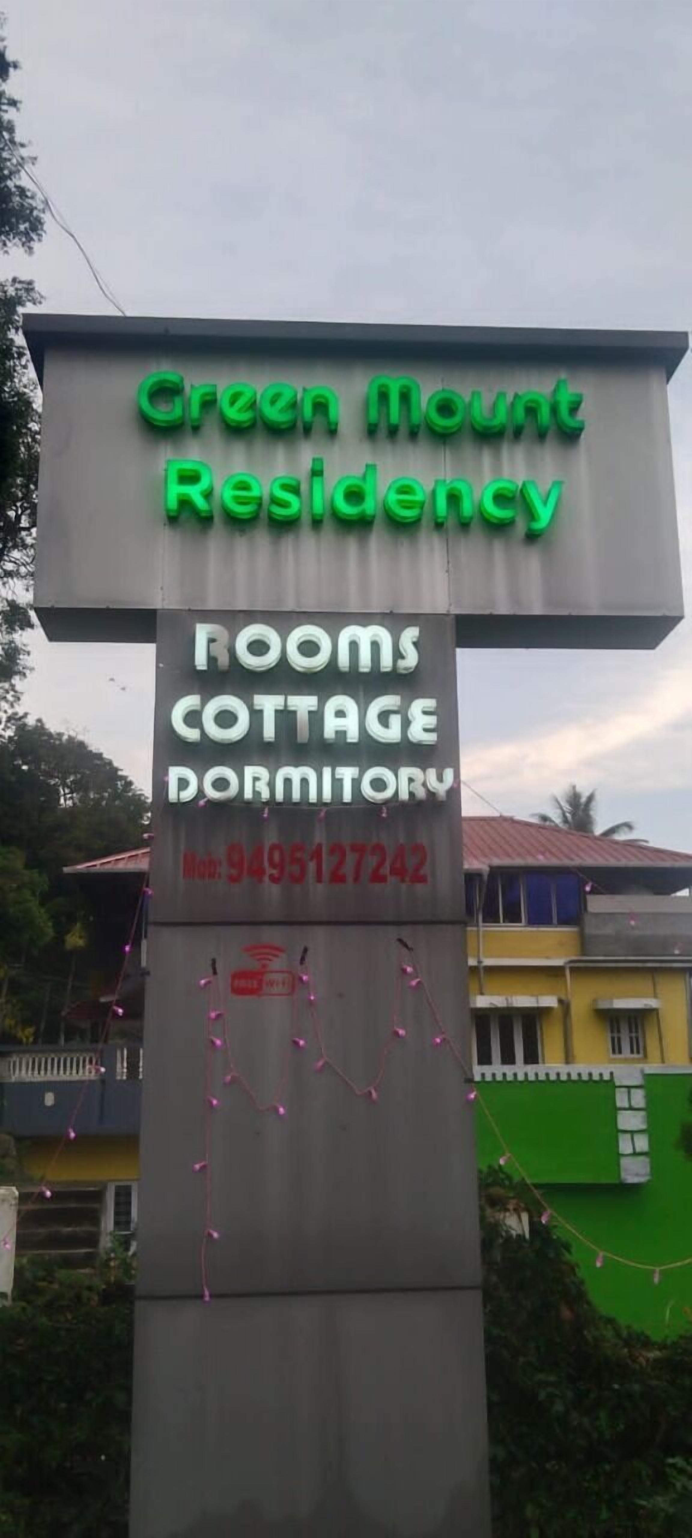 A sign for Green Mount Residency with a contact number.
