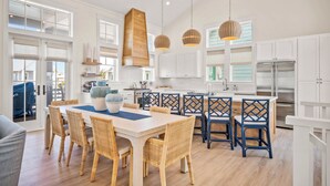 A spacious kitchen with white cabinets, a large island, and modern appliances.