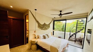 A bedroom with a bed, a hammock, a ceiling fan, and a staircase leading to a balcony. - 2-BD Deluxe Villa 2 Private Pools & Grill (Tulum)