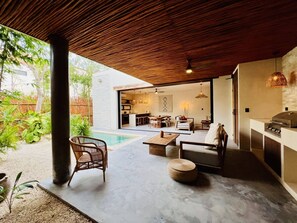 A modern outdoor living area with a pool, seating, and a kitchen area. - 2-BD Deluxe Villa 2 Private Pools & Grill (Tulum)